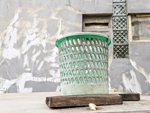Green plastic basket with hole pattern placed on a wooden block against a t.. Stock Photos