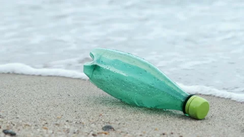 Green plastic bottle on the beach. Stock Footage