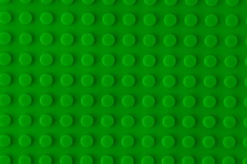 Green plastic building blocks baseplate texture, top view toy brick board p.. Stock Photos