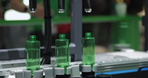 Green plastic containers move along industrial conveyor system to fill cosmetics 스톡 동영상 346231471