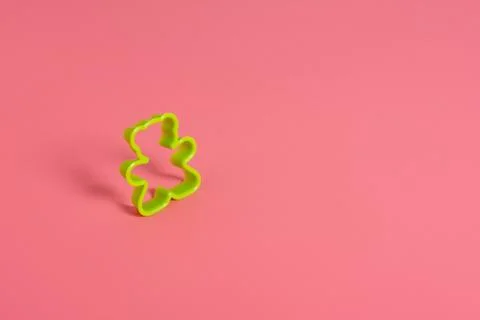 Green plastic cookie cutter for making cookies in the shape of a teddy bear o Stock Photos