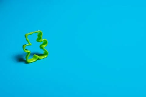 Green plastic cookie cutter for making cookies in the shape of a teddy bear o Stock Photos