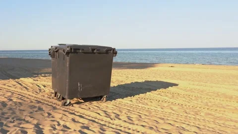 Green plastic dumpster staying on sandy beach of sea or ocean. Stock Footage 162855508