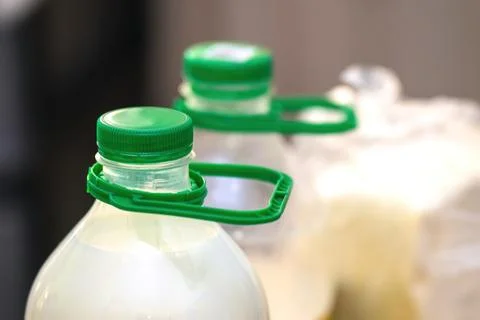Green plastic handle attached to a large milk bottle for easy carrying, pra.. Foto stock