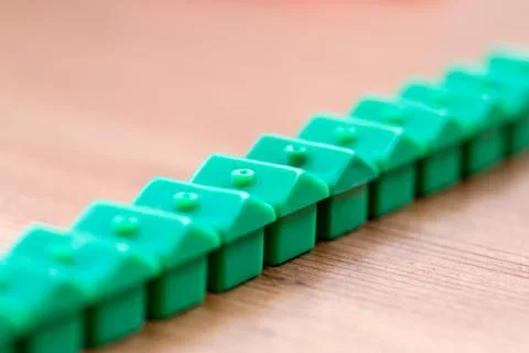 Green Plastic House Models in a Diagonal Row Stock Photos