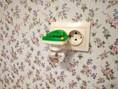 A green plastic mosquito repellent with a solution and a lit indicator in a.. Stock Photos