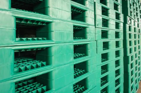 Green plastic pallets in warehouse. Stock Photos