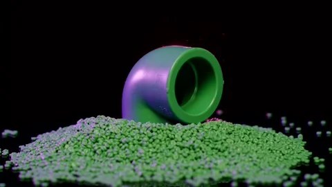 Green Plastic Pipe Elbow on Granules Pile, Macro Product Shot Stock Footage 342279434