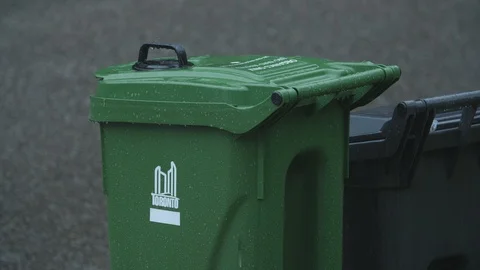 Green plastic recycling bin in the rain. Roadside ready for pickup. Toronto. Stock Footage 93760434