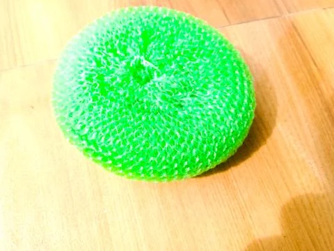 A green plastic scrubber placed on the floor. Stock Photos