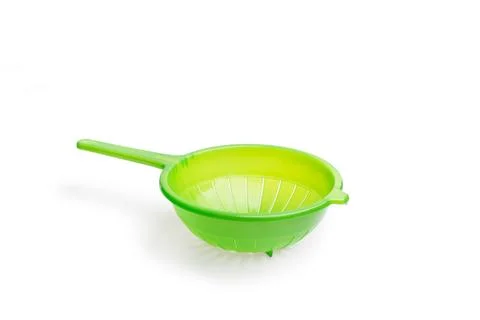 A green plastic strainer on a white background with copy space Foto stock