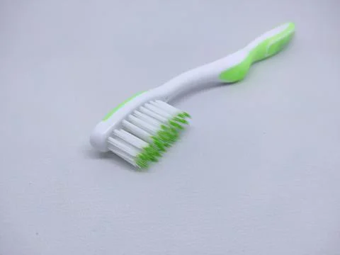 Green plastic toothbrush sideways isolated on white Stock Photos