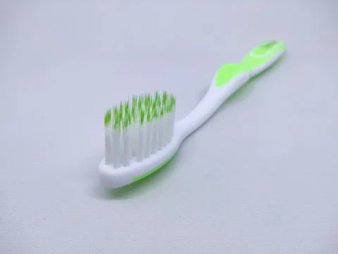 Green plastic toothbrush sideways isolated on white Stock Photos