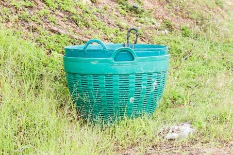Green plastic trash basket. Stock Photos