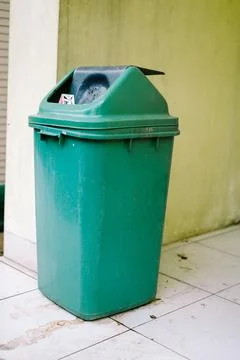 A green plastic trash bin, simple and functional, ideal for outdoor or indo.. Stock-Fotos