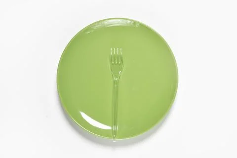 Green plate and plastic fork with spoon Stock Photos