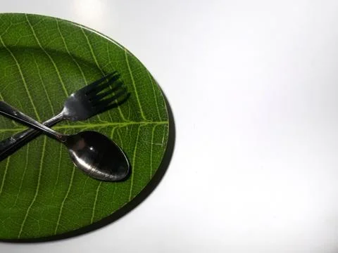 Green plate leaf theme isolated white background with spoon and fork 스톡 사진