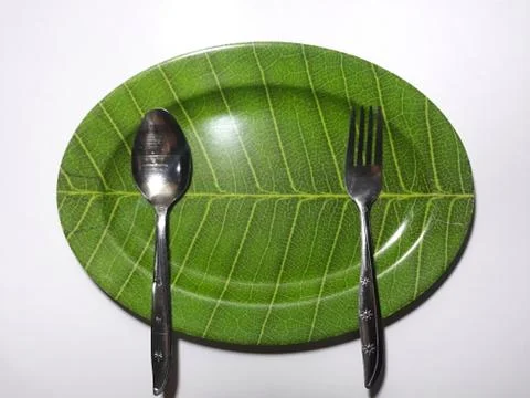 Green plate leaf theme isolated white background with spoon and fork Stock Photos