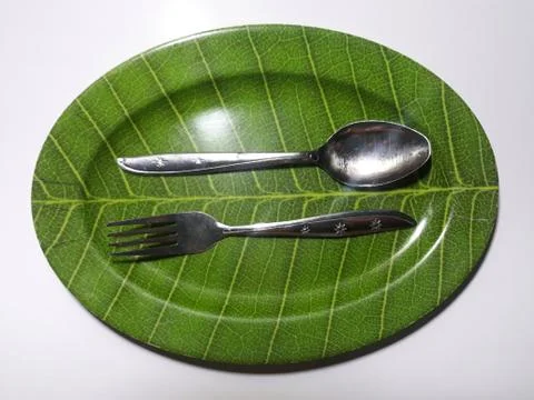 Green plate leaf theme isolated white background with spoon and fork 스톡 사진