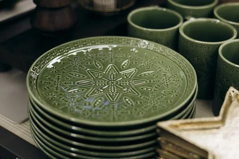 Green plates with decorative patterns arranged for Christmas holiday. Stock Photos