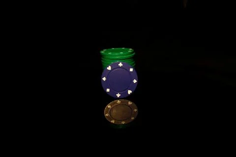 Green pocker chips stack with a blue chip in front isolated on black with ref Stock-Fotos