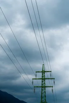 Green pole of electric current with gray clouds in the background Stock Photos