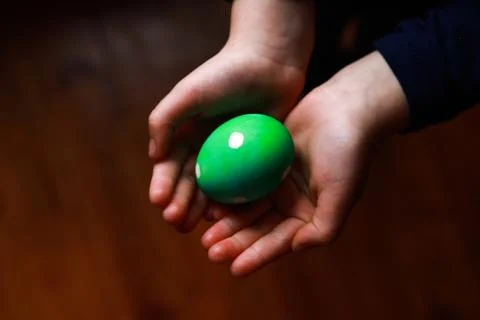 Green polka dot easter egg in child's hands Stock Photos