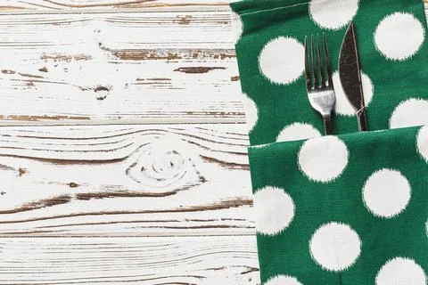 Green polka dot napkin on weathered wooden background Stock Photos