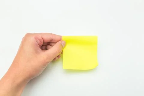 Green post-it note with hand on white background - Image Stock Photos