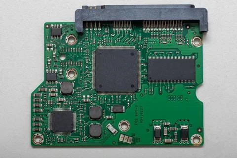 Green printed circuit board features various electronic components, including Stock Photos