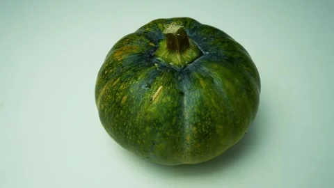 Green Pumpkin on Light Background, A green pumpkin with a smooth surface an.. Stock Footage 305044956