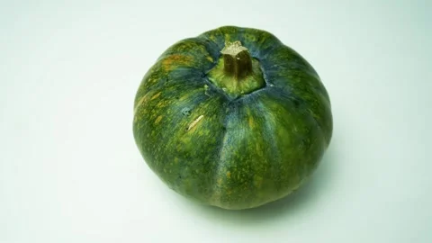 Green Pumpkin on Light Background, A green pumpkin with a smooth surface an.. Vidéo 305045022
