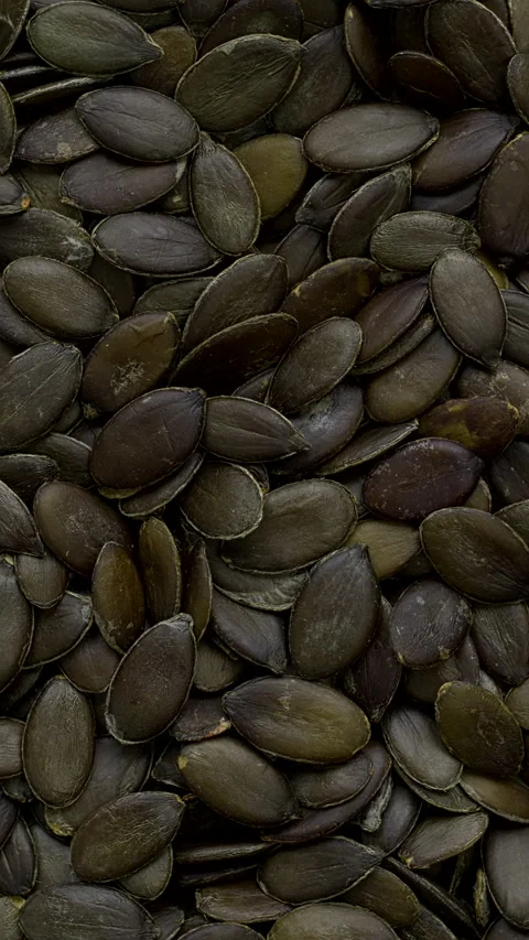 Green pumpkin seeds background texture.  Vertical video. Stock Footage 297621157