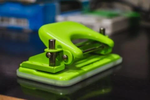 Green Punching machine selective focus on the wooden table Stock Photos