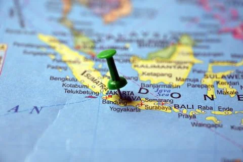 Green Push Pin Pointing Java Island on Paper World Map Macro Close Up with .. Stock Photos