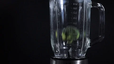 Green raw broccoli is falling down in blender on black background Stock Footage 102616970