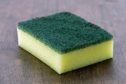 Green rectangular scouring pad with yellow sponge is used for cleaning. Stock Photos