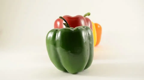 Green, Red, Yellow and Orange Peppers Against White - Dolly Left Stock Footage 23465341