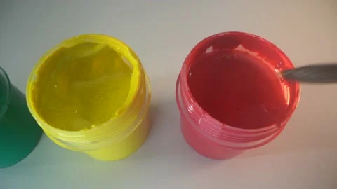 Green, redd and yellow paint cans on the white surface. Painter dips the blush Stock Footage 141368448