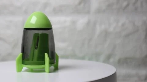 Green rocket-shaped pencil sharpener on a clean white background. Perfect f.. Stock Photos