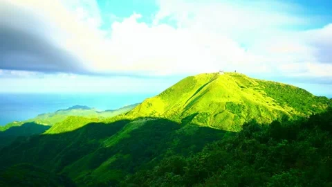 Green rolling hills meet ocean under bright blue sky with clouds. Stock-Footage 341136909