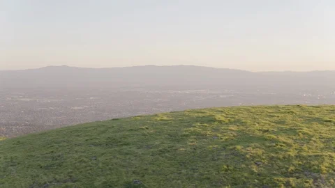 Green rolling landscape overlooking the city at a distance Stock Footage 92048862