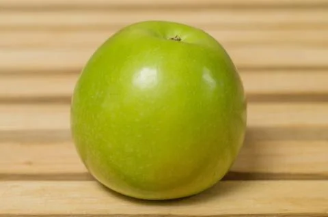 Green round Apple on the table. Stock Photos