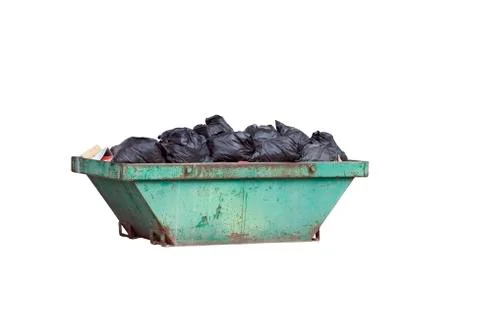 Green rusty container with black garbage bags Foto stock