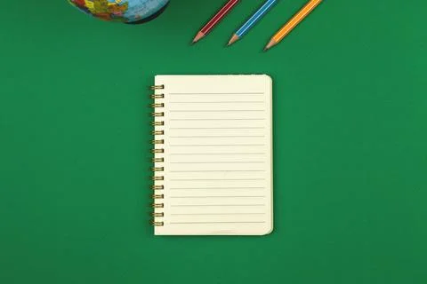 Green school table with blank lined notebook and pencils top view photo with  Stock Photos