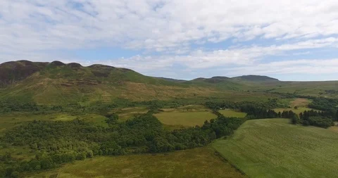 Green Scottish Landscape with White Clouds Pull Back Drone Shot 動画素材 97572103