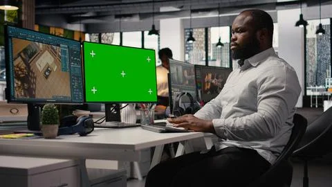 Green screen and architectural software on dual monitors in creative agency Stock Photos