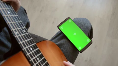 Green screen and chroma key of mobile phone. Online guitar courses. Stock Footage 152340426