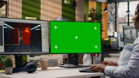Green screen and video game software on dual monitors at the office Stock Photos