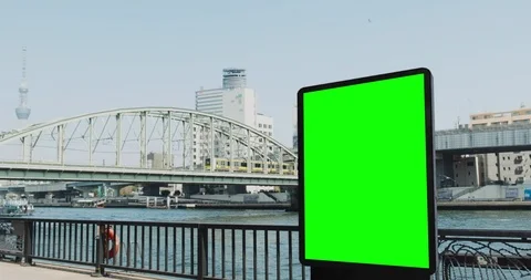 Green screen billboard on a riverside against big city, subway goes over the Vidéo 106984997